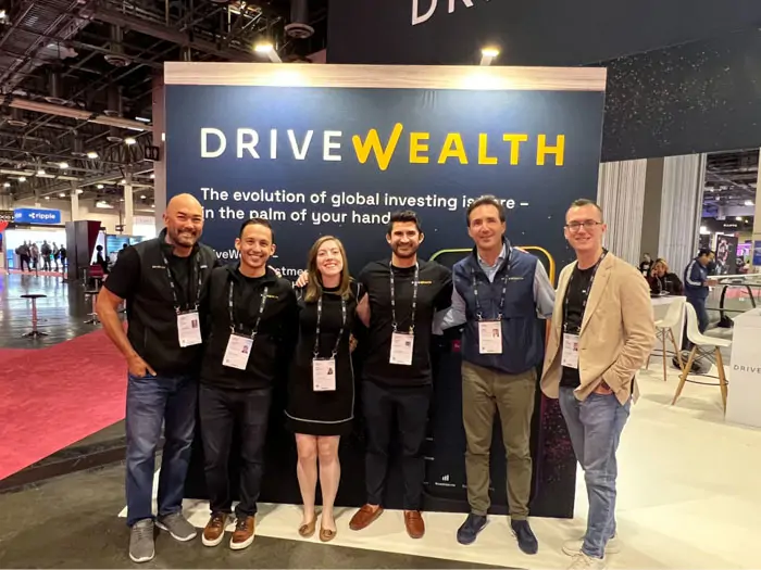 DriveWealth team at a booth showcasing asset management software development innovations